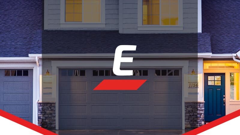 Front view of a modern suburban home featuring two gray garage doors with white trim, showcasing professional garage door installation by Garage Door Experts